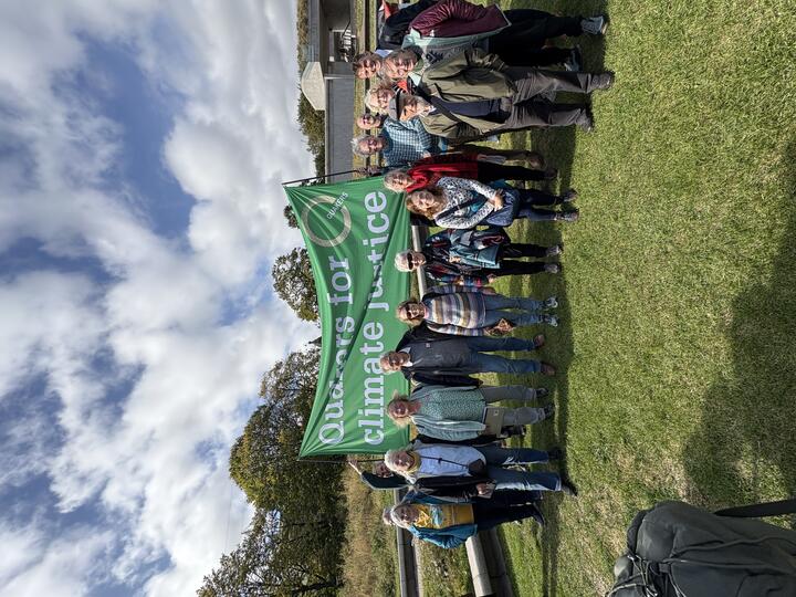 Quakers in Scotland standing under Quakers for climate justice green banner, outside the Scottish Parliament