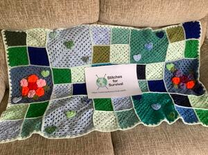 Stiches for survival from https://stitchesforsurvival.earth Crocheted blanket and stiches for survival logo